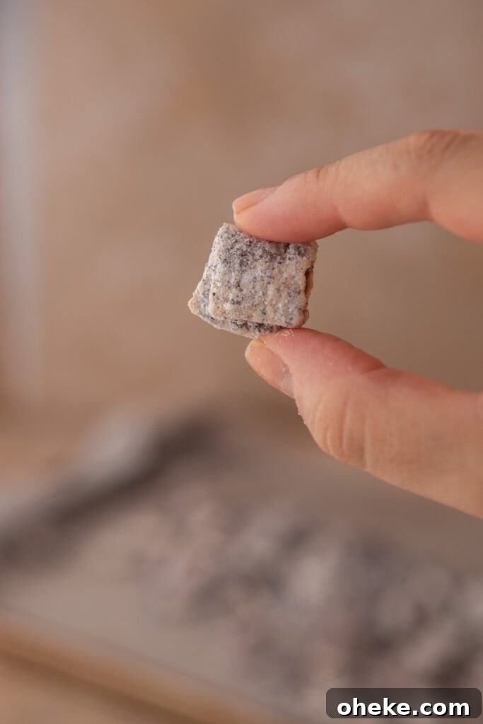 cookies and cream muddy buddies recipe in a hand